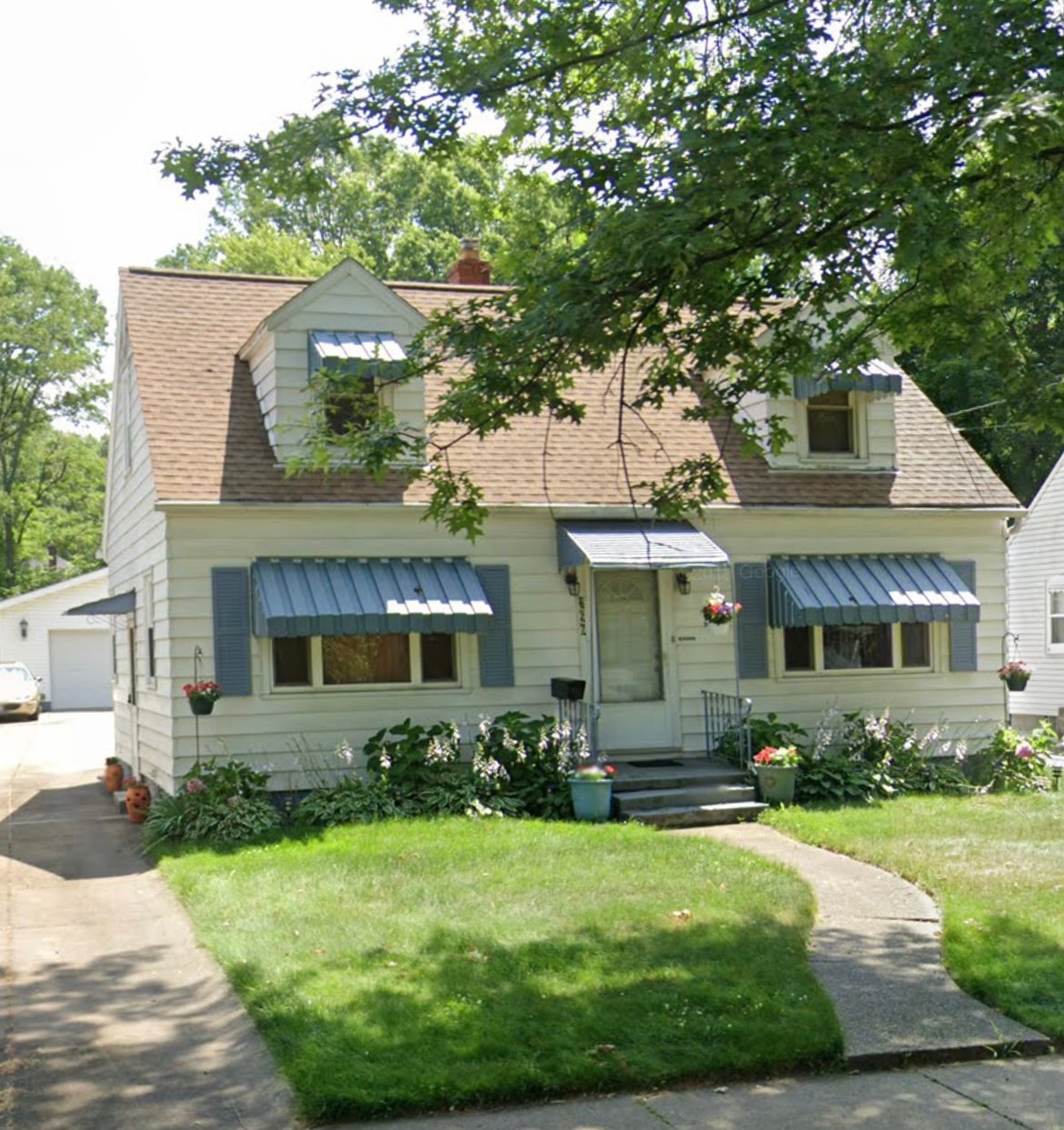 Before Cape Cod exterior house painting in Akron Ohio — Akron painter prepping white Cape Cod siding with blue shutters, Akron painters residential exterior painting project before