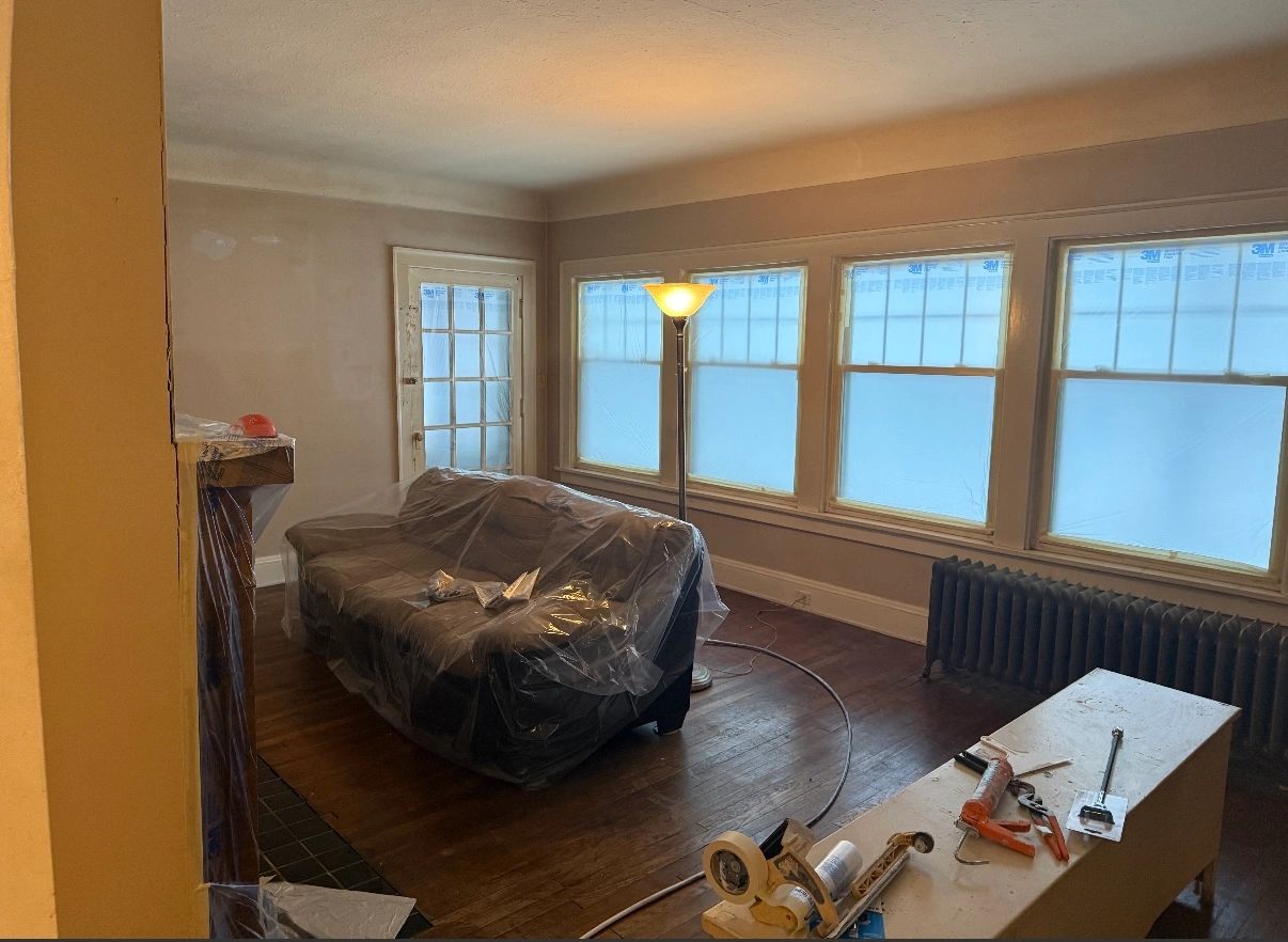 Interior room before — furniture covered for prep